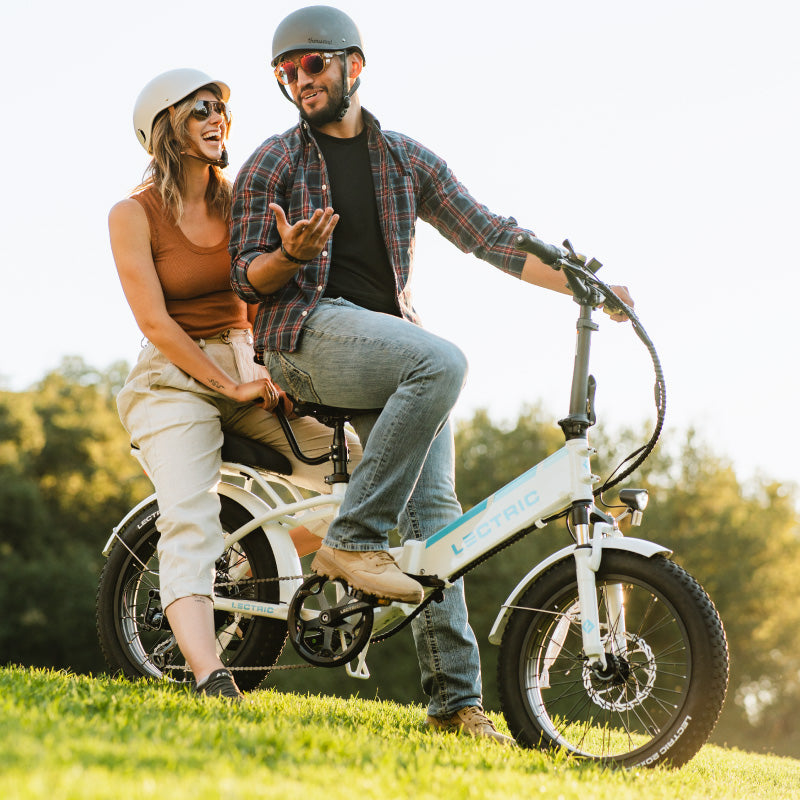Cute couple riding on Lectric eBike passenger pack. One bike two people.